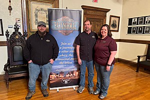 Way Out West Paranormal team stand before the organization's sign in the Knights of Pythias building.  Credit: Phylicia Peterson, TSM SE WY